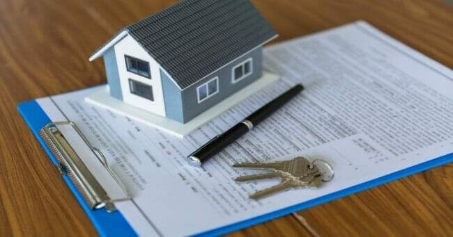 mortgage-papers-with-house-model-GettyImages-1309843027-1200x630-1-650x341